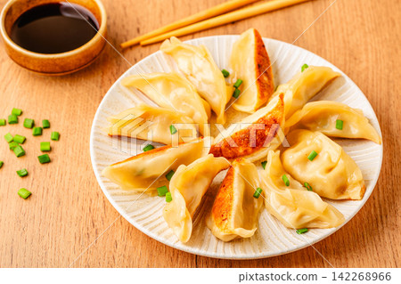 Dumplings served on a plate with green onions Dumplings served on a plate with green onions 142268966