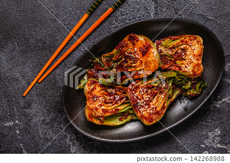 Cooked cabbage bok choy served on a plate with spices. Cooked cabbage bok choy served on a plate with spices. 142268988