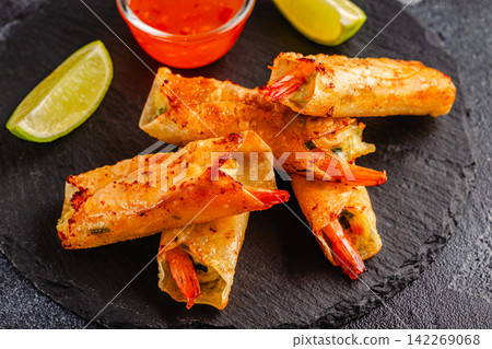 Fried spring rolls with shrimps served with sauce and lime Fried spring rolls with shrimps served with sauce and lime 142269068
