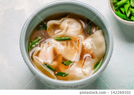 Warm bowl of wonton soup served with green onions. Warm bowl of wonton soup served with green onions. 142269102