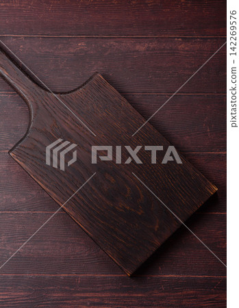 A square wooden cutting board for home food preparation. A wooden cutting board A square wooden cutting board for home food preparation. A wooden cutting board 142269576