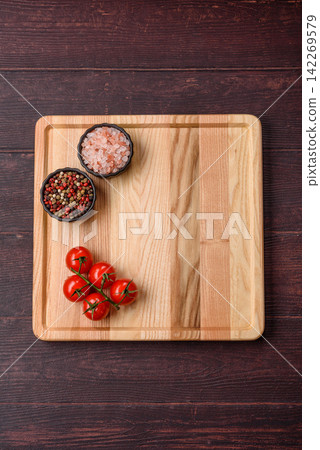 A square wooden cutting board for home food preparation. A wooden cutting board A square wooden cutting board for home food preparation. A wooden cutting board 142269579