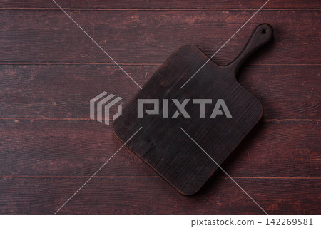 A square wooden cutting board for home food preparation. A wooden cutting board 142269581