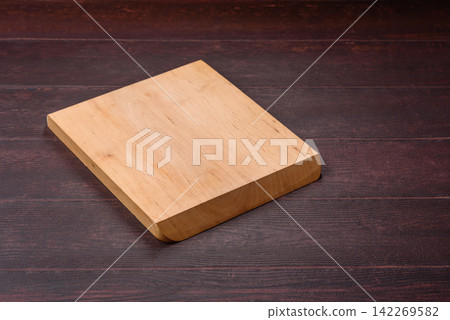 A square wooden cutting board for home food preparation. A wooden cutting board A square wooden cutting board for home food preparation. A wooden cutting board 142269582