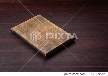 A square wooden cutting board for home food preparation. A wooden cutting board A square wooden cutting board for home food preparation. A wooden cutting board 142269584