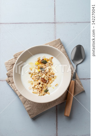 Healthy natural yogurt breakfast with granola on blue tile background Healthy natural yogurt breakfast with granola on blue tile background 142270041