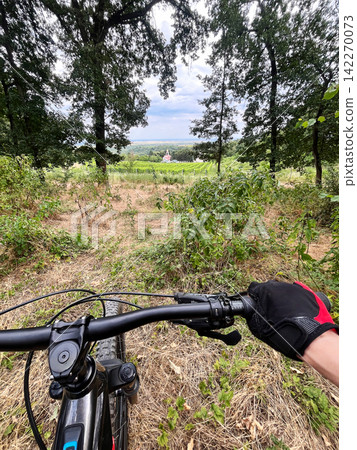 Cycling through a rural village with scenic countryside views 142270073