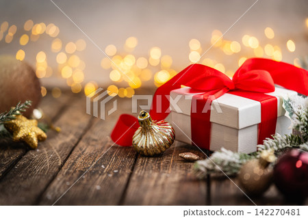 Classic White Gift Box with Red Ribbon on Wooden Table Classic White Gift Box with Red Ribbon on Wooden Table 142270481