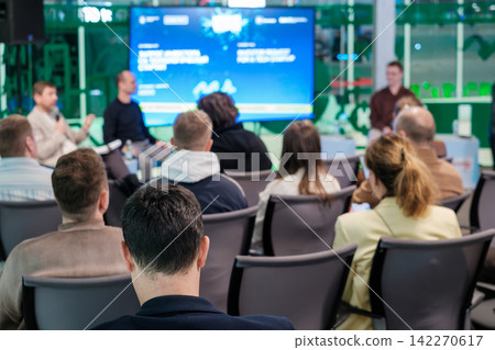 Attendees watch speakers during indoor panel discussion Attendees watch speakers during indoor panel discussion 142270617
