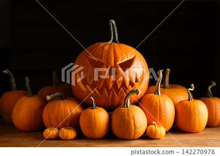 Large carved Halloween pumpkin surrounded by assorted orange gourds Large carved Halloween pumpkin surrounded by assorted orange gourds 142270978