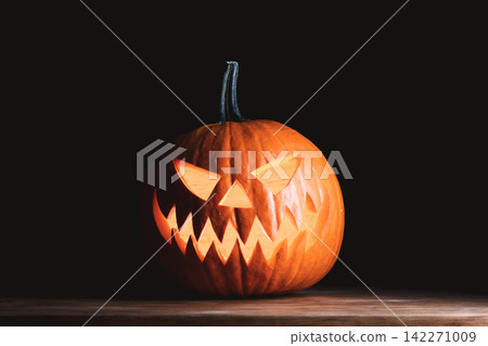 Scary carved pumpkin lantern with candlelight Scary carved pumpkin lantern with candlelight 142271009