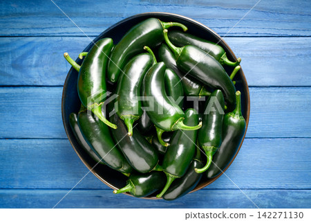Overhead bowl with glossy green jalapeno peppers o Overhead bowl with glossy green jalapeno peppers o 142271130