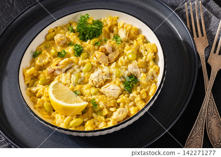 Creamy saffron chicken risotto in a bowl, close-up Creamy saffron chicken risotto in a bowl, close-up 142271277