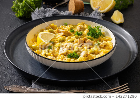 Creamy chicken and saffron rice bowl on a table Creamy chicken and saffron rice bowl on a table 142271280