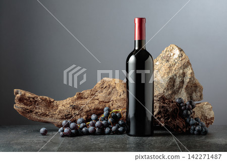 Bottle of red wine on a grey background. Bottle of red wine on a grey background. 142271487