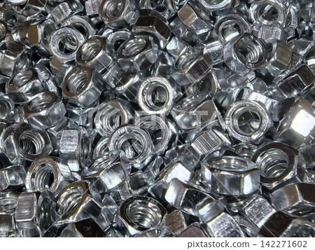 Collection of shiny metal nuts arranged in a chaotic yet beautiful manner Collection of shiny metal nuts arranged in a chaotic yet beautiful manner 142271602