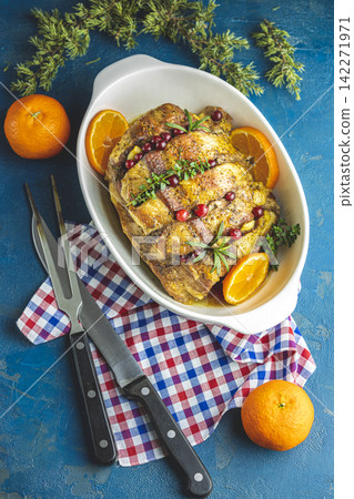 Roasted pork in white dish, christmas baked ham with cranberries, tangerines, thyme, rosemary, garlic on light table surface Roasted pork in white dish, christmas baked ham with cranberries, tangerines, thyme, rosemary, garlic on light table surface 142271971