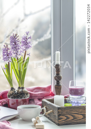 Early spring still life scene. Cup of coffee and marshmallow, opened notebook, pink plaid and candles on windowsill. Cozy Easter, vintage feminine styled photo 142272034