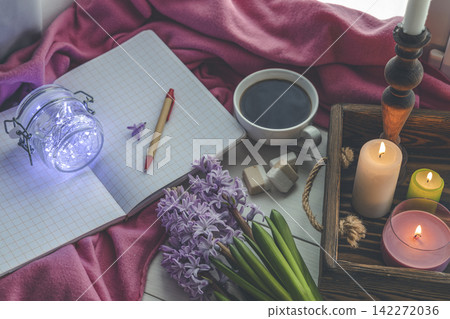 Early spring still life scene. Cup of coffee and marshmallow, opened notebook, pink plaid and candles on windowsill. Cozy Easter, vintage feminine styled photo 142272036
