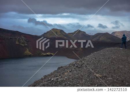 Hiker Standing at Volcanic Lake in Iceland Highland Landscape Hiker Standing at Volcanic Lake in Iceland Highland Landscape 142272510