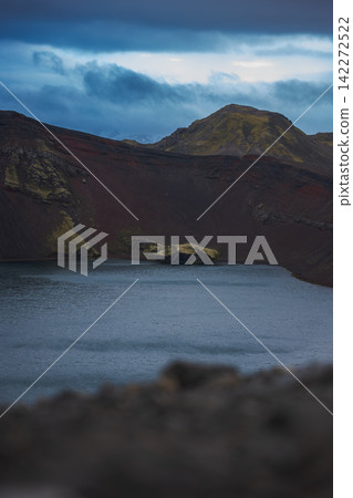 Volcanic crater lake with red lava fields Iceland Volcanic crater lake with red lava fields Iceland 142272522