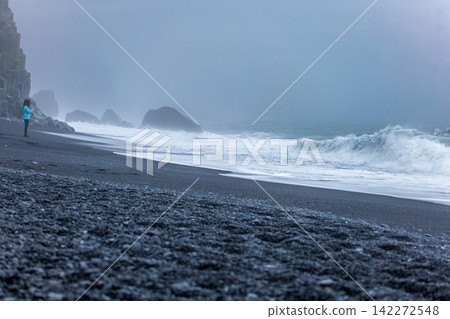 Solitary Traveler on Black Sand Beach Iceland Misty Morning Waves Solitary Traveler on Black Sand Beach Iceland Misty Morning Waves 142272548
