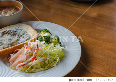 一張構圖寬廣的照片捕捉了早餐的場景,包括吐司、沙拉和湯。 一張構圖寬廣的照片捕捉了早餐的場景,包括吐司、沙拉和湯。 142272592
