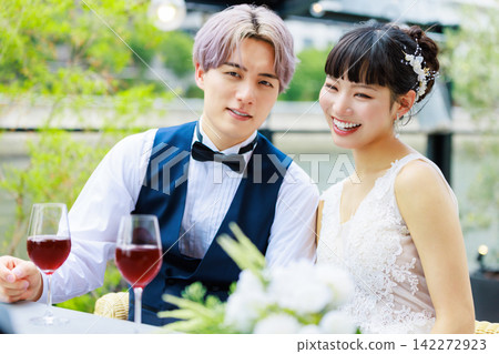 新郎新娘在水邊露台喝酒。 142272923