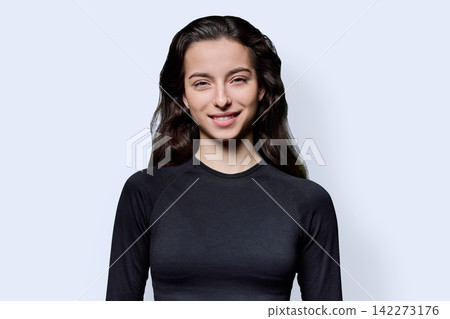 Smiling young female student looking at camera against white background Smiling young female student looking at camera against white background 142273176