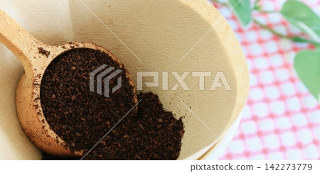 Ground coffee with a long, narrow margin and a wooden spoon. Ground coffee with a long, narrow margin and a wooden spoon. 142273779