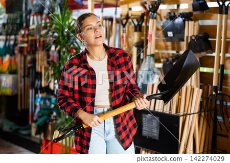 Female farmer choosing shovel in gardening store Female farmer choosing shovel in gardening store 142274029