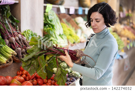 Woman choosing beets in the store 142274032