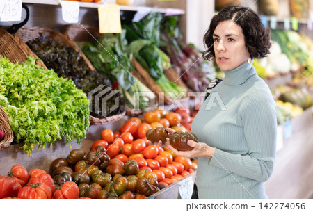 European woman choosing tomatoes European woman choosing tomatoes 142274056