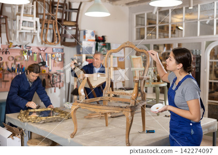 woman restorer spackling antique chair surface getting piece of furniture ready for further coloring 142274097