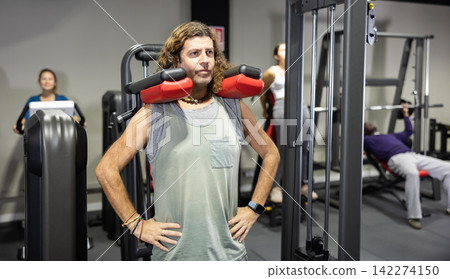 Caucasian man doing exercises on calf raise machine in gym 142274150