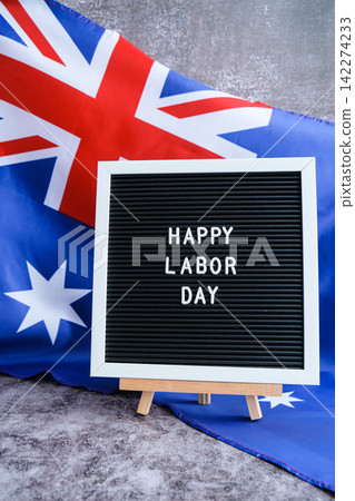 Australian flag and message board text HAPPY LABOR DAY festive holiday greetings. Concept of workers rights and public holiday, use in labor-themed marketing Australian flag and message board text HAPPY LABOR DAY festive holiday greetings. Concept of workers rights and public holiday, use in labor-themed marketing 142274233