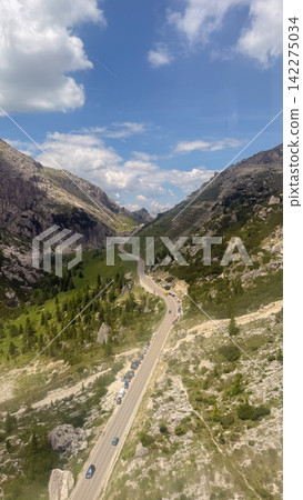 Dolomite alps mountain pass road with winding cars Dolomite alps mountain pass road with winding cars 142275034