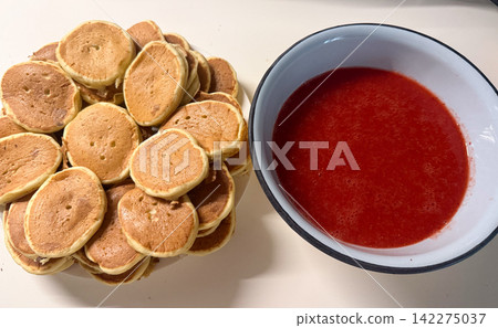 Pile of mini pancakes with strawberry sauce Pile of mini pancakes with strawberry sauce 142275037