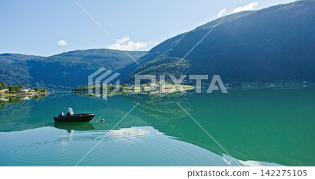 Boat floating on a calm norwegian fjord water Boat floating on a calm norwegian fjord water 142275105
