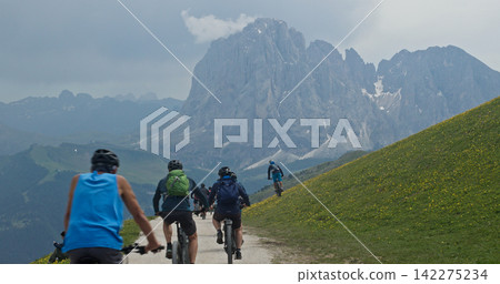 Group mountain biking on trail in dolomites, italy Group mountain biking on trail in dolomites, italy 142275234