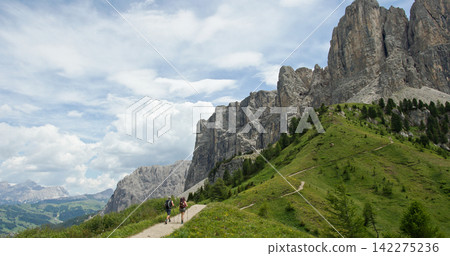 Hikers trekking mountain trail sella pass dolomites italy Hikers trekking mountain trail sella pass dolomites italy 142275236