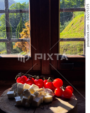 Rustic window view with tomatoes and cheese snack 142275375