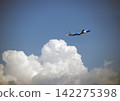 An airplane flying above a cumulonimbus cloud 142275398