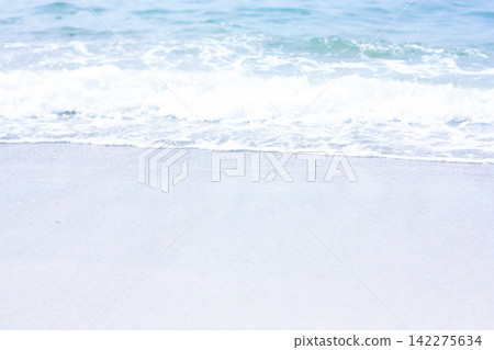 Waves crashing against the blue sea and sandy beach Waves crashing against the blue sea and sandy beach 142275634
