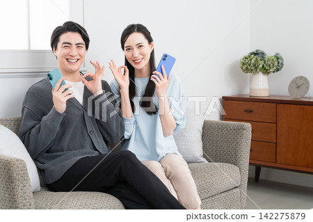 Young men and women searching on their smartphones: Lifestyle image Young men and women searching on their smartphones: Lifestyle image 142275879