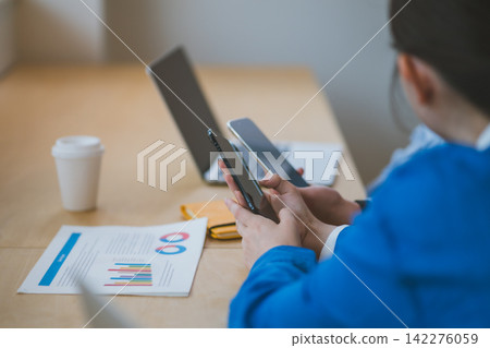 在辦公室工作的年輕男女們將智慧型手機靠近彼此,試圖進行無線通訊。 在辦公室工作的年輕男女們將智慧型手機靠近彼此,試圖進行無線通訊。 142276059