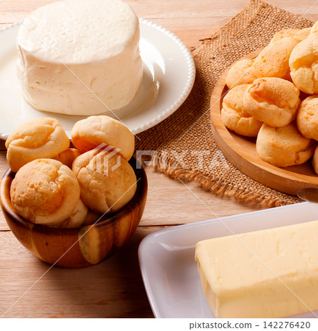 Minas Gerais cuisine featuring homemade cheese bread, fresh Minas cheese, and butter on a rustic wooden table Minas Gerais cuisine featuring homemade cheese bread, fresh Minas cheese, and butter on a rustic wooden table 142276420