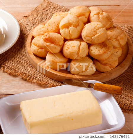 Minas Gerais cuisine featuring homemade cheese bread, fresh Minas cheese, and butter on a rustic wooden table Minas Gerais cuisine featuring homemade cheese bread, fresh Minas cheese, and butter on a rustic wooden table 142276421
