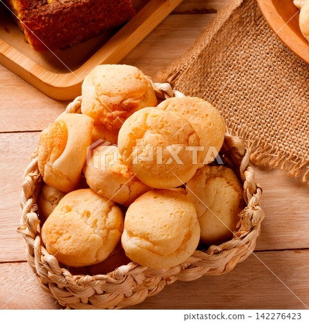 Homemade Brazilian cheese bread served on a wooden platter, accompanied by fresh Minas cheese, butter, and black coffee Homemade Brazilian cheese bread served on a wooden platter, accompanied by fresh Minas cheese, butter, and black coffee 142276423