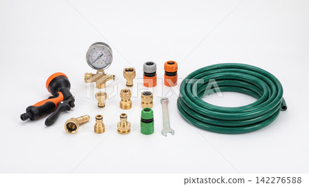 Garden hose coiled with spray nozzle and various brass fittings and connectors on white background fittings connectors watering equipment pressure irrigation agriculture accessory maintenance 142276588